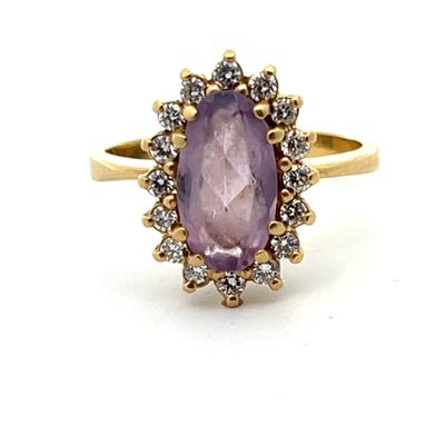 gros plan d'une bague avec une pierre violette entourée de diamants