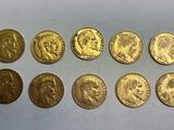 un tas de pièces d'or posé sur une surface blanche