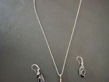 a close up of a necklace and earrings on a table