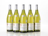 four bottles of white wine are lined up on a white surface