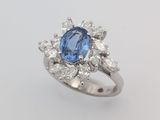 gros plan d'une bague avec une pierre bleue entourée de diamants blancs