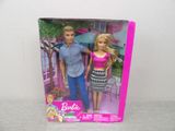 barbie and ken doll in a box on a table