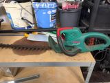 a green and red leaf blower on a workbench