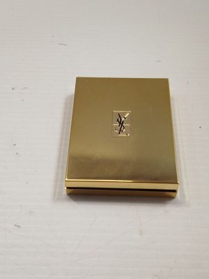 an image of a gold compact case with a monogram on the front