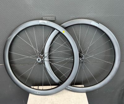 une paire de roues à rayons exposée devant un mur