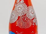a red glass bottle with a blue and white design on it