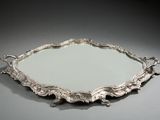 un plateau en argent richement décoré, orné d'un miroir en son centre