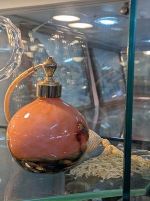une vitrine en verre sur laquelle est posée une bouteille de parfum