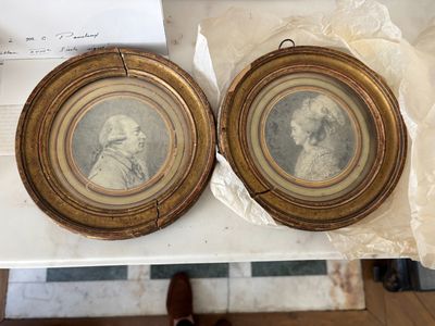 une paire de portraits encadrés représentant deux hommes, posés sur une table