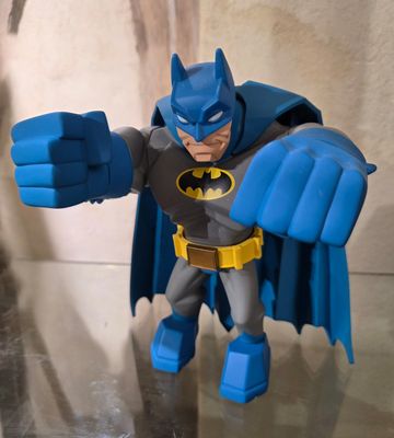 une figurine représentant Batman avec une cape bleue