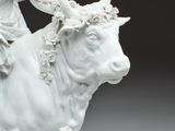 a statue of a woman riding a bull with a flower crown on her head