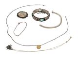 several different necklaces and bracelets are arranged on a white surface