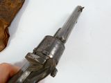 a hand holding a gun that is next to a piece of leather