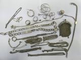 a lot of silver jewelry on a white surface