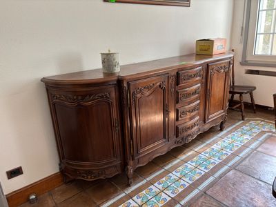 une photo d'un salon avec un sol carrelé et un buffet