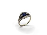 a close up of a ring with a blue stone in it