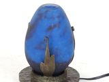 a blue vase with a bird on it on a stand