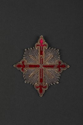 a close up of a red and gold cross on a black background