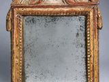 un miroir ancien avec un cadre doré sur lequel est représenté un visage