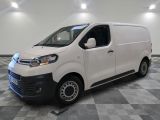 la camionnette blanche est garée sur un sol carrelé en damier