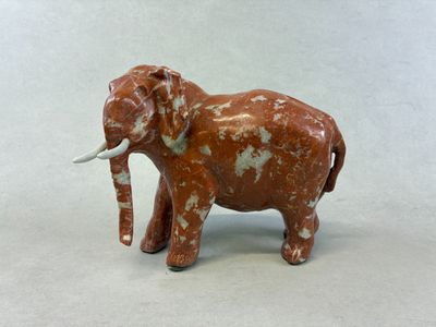 statue of an elephant with tusks on a white background
