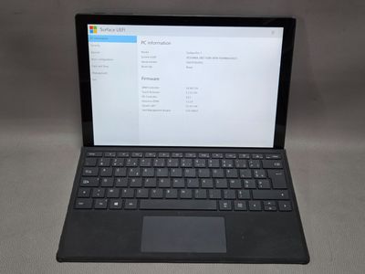 un ordinateur portable ouvert posé sur une table blanche