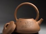 teapot with lid and cover in the shape of a dragon on a gray background