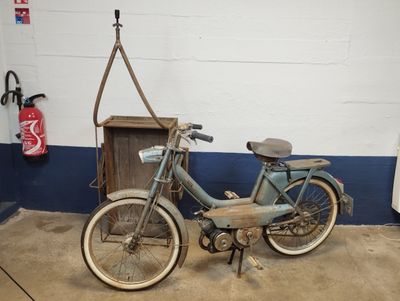 a blue bike parked in a garage next to a wooden box