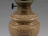 pair of antique brass lamps on pedestals on a gray background