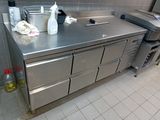 stainless steel counter top in a commercial kitchen with a lot of items on it