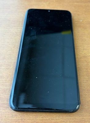 l'arrière d'un téléphone portable noir posé sur une table en bois