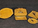 quatre pièces de poterie jaune posées sur une surface noire