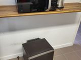 un micro-ondes et un grille-pain posés sur une étagère