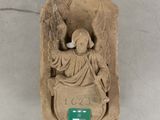 a statue of an angel holding a bird on a plaque