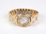 an image of a woman ' s watch on a gold bracelet