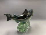 sculpture en verre représentant un poisson posé sur un rocher, sur un fond blanc