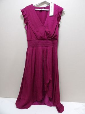 une robe violette suspendue à un cintre contre un mur