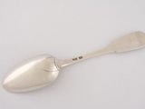 silver spoon on a white surface with a small spoon in the middle of it