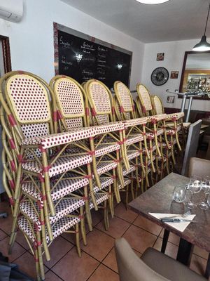 tables and chairs in a restaurant with a chalkboard on the wall