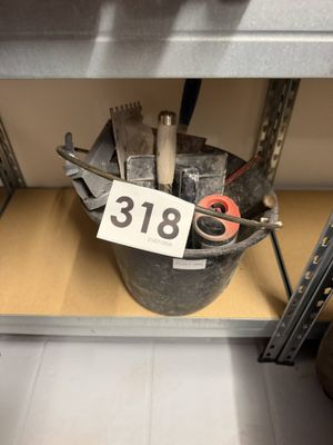 un seau rempli d'outils posé sur une étagère, avec une étiquette de prix