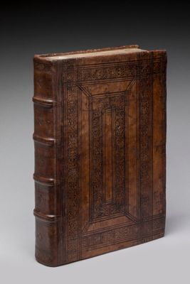 un vieux livre relié en cuir, dont la couverture est ornée d'un motif décoratif