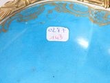 a blue vase with gold trim and a price tag on it