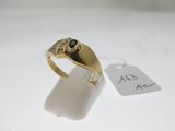 Gros plan sur une bague en or ornée d'une pierre noire