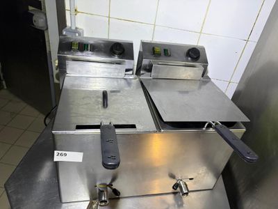two deep fryers sitting on a counter in a kitchen