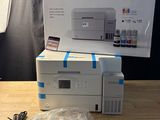 the printer is sitting on the table next to the box