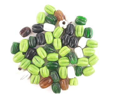 a pile of green and black beads on a white surface