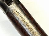 an old gun with a wooden handle on a white surface
