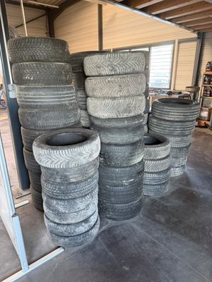 une grande quantité de pneus empilés les uns sur les autres dans un garage