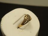 une image représentant une bague en or posée sur un récipient blanc