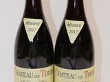 two bottles of wine sitting on top of a table next to each other